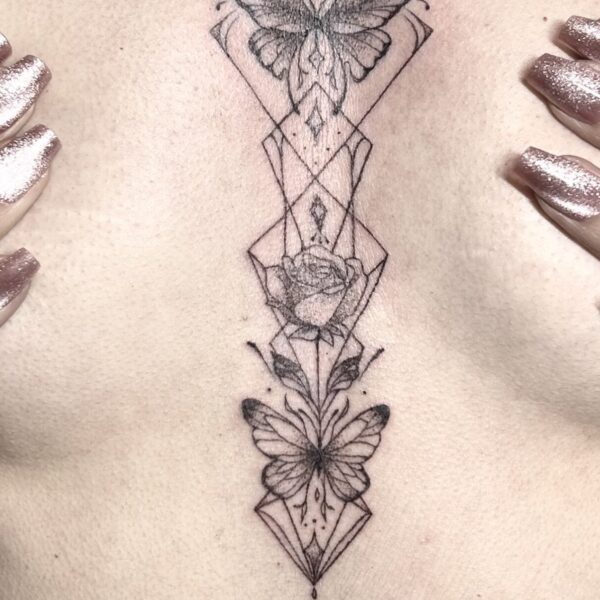 Tatouage fine line ornemental au sternum avec papillons, rose et motifs géométriques