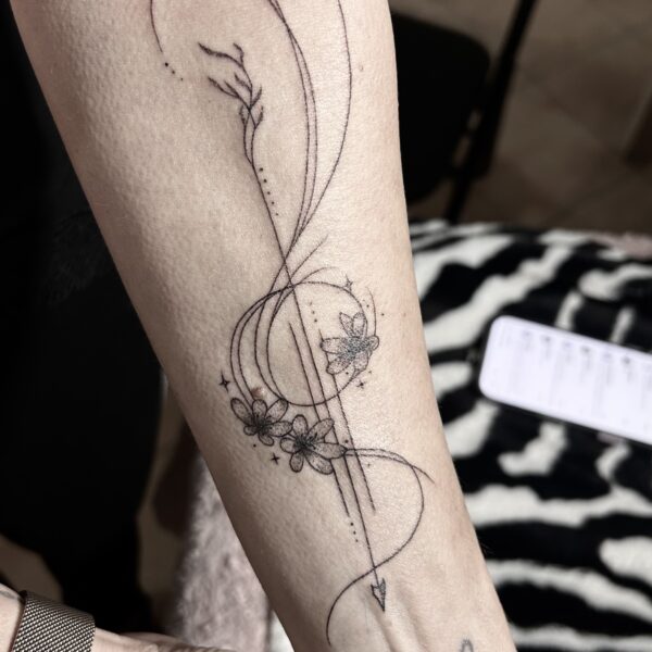 Tatouage floral en linework sur le bras avec fleurs et feuillages