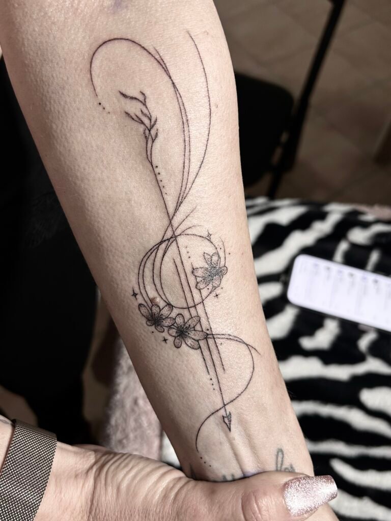 Tatouage floral en linework sur le bras avec fleurs et feuillages